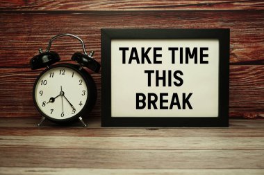 Ahşap arkaplanda alarm saati olan Bu Ara metnini al