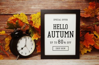 Hello Autumn İndirim% 80 indirimli alarm saati ve ahşap arka planda akçaağaç yaprağı süslemesi