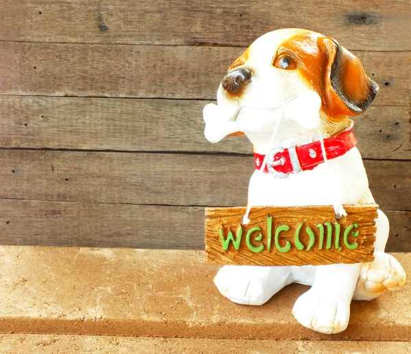 Ceramic welcome dog on wooden background still life — Stock Photo, Image