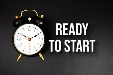 Siyah arkaplanda alarm saati ile metne başlamaya hazır
