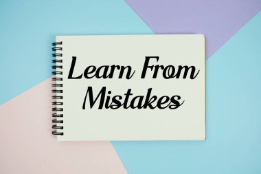 Not defterinde yazılan hatalardan öğren düz arkaplanda çok renkli pastel üzerine uzan