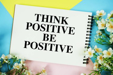 Not defterine yazılmış, çiçek süslemeleri düzleştirilmiş olumlu metni düşünün çok renkli pastel arka planda yatıyordu