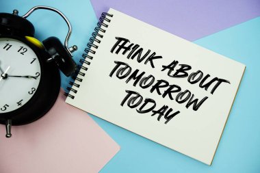 Bugünü Düşün. Not defterine yazılan alarm saati düz. Çok renkli pastel arka planda yatıyordu.