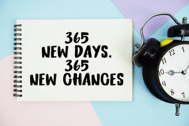 365 Yeni Gün, 365 Yeni Şans metni alarm saatinin düz olduğu not defterine yazıldı çok renkli pastel arka planda yatıyordu