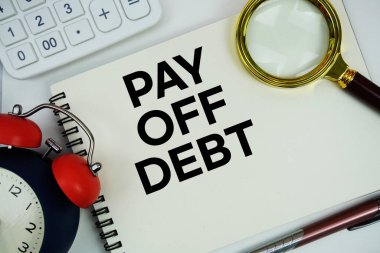 Alarm saati, büyüteç ve beyaz arkaplanda hesap makinesi ile not defterine yazılan Ödeme Borcu metni