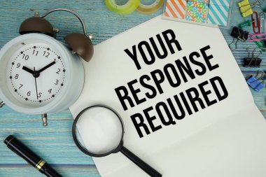 Yanıtınız ofis malzemeleri, bir büyüteç ve mavi ahşap bir yüzey üzerinde bir saat ile çevrili bir kağıt üzerinde metin gerektiriyordu