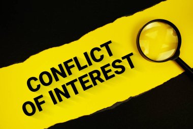 Siyah kağıt yırtılmış ve büyüteçle sarı metinde çıkar çatışması