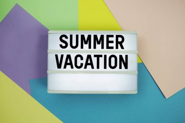 Işık kutusundaki yaz tatili metni renkli pastel arka planda yatıyordu