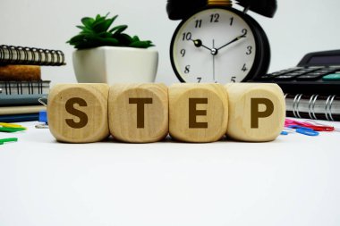 Beyaz arkaplanda alarm saati ve hesap makinesi olan STEP alfabesi harfleri