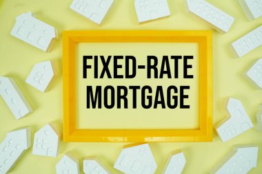 Sarı arkaplanda ev modelleriyle sabitlenmiş ipotek metni