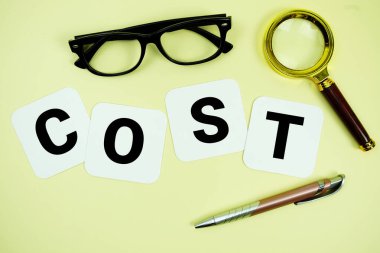 Sarı arka planda büyüteç, gözlük ve kalemle alfabe harfleri.