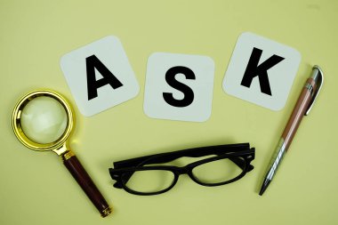 Sarı zemin üzerinde büyüteç, gözlük ve kalem bulunan soru harfleri