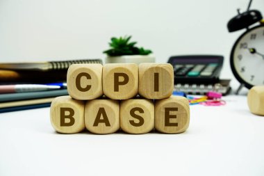 Beyaz zemin üzerinde hesap makinesi ve alarm saati olan CPI temel alfabe harfleri