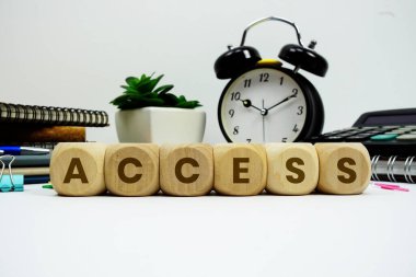 Beyaz zemin üzerinde alarm saati ve hesap makinesi olan ACCESS alfabe harfleri
