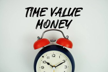 Alarm saati düz olan Zaman Değer Parası (TVM) metni beyaz arkaplan üzerinde yatıyordu