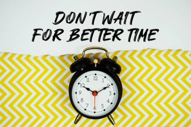 Sarı simge arkaplanındaki alarm saati ile kağıda yazılmış Daha İyi Zaman metnini bekleme