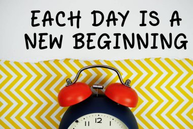 Her Gün, sarı simge arkaplanındaki alarm saatiyle kağıda yazılmış yeni bir başlangıç metni