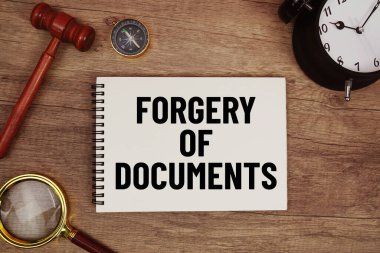 Not defterine tahta tokmak ve büyüteçle yazılmış sahte belge mesajı ahşap arka planda duruyordu.