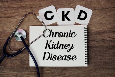 CKD Kronik Böbrek Hastalığı metni not defterine steteskop ile ahşap arka planda yazılmış.