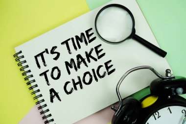 Not defterine Pastel arkaplanda alarmlı saat ile bir seçim metni yazma zamanı.