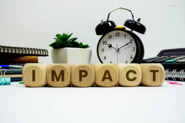 Beyaz zemin üzerinde alarm saati ve hesap makinesi olan IMPACT alfabe harfleri