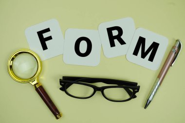 Sarı zemin üzerinde büyüteç, gözlük ve kalem olan eski alfabe harfleri