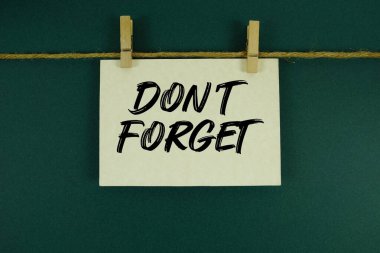 Kağıt kartta yazılı olan iple ve tahta raptiyeyle asılı metni unutma.