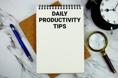 Günlük Üretim İpuçları not defterine alarm saati ve mermer zemin üzerindeki büyüteçle yazılmış metinler