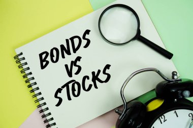 Not defterine yazılan ve pastel arka planda alarmlı hisse senedi vs metni