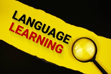 Siyah kağıt yırtılmış ve büyüteçle sarı üzerine dil öğrenme metni