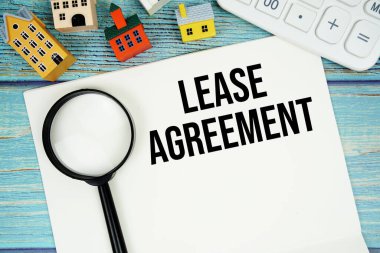 Hesap makinesi, büyüteç ve ahşap arka planda ev modeli ile 