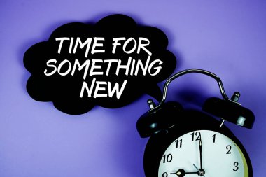 Konuşma balonunda mor zemin üzerinde alarm saati olan yeni bir metin zamanı