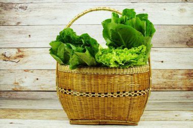 Taze çiğ Iceberg, Romaine ve Green Cos marulları bambu sepetinde ahşap arka planda
