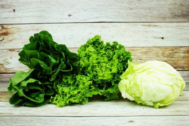 Taze çiğ buzdağı, Romaine ve Yeşil Çünkü marul ahşap arka planda