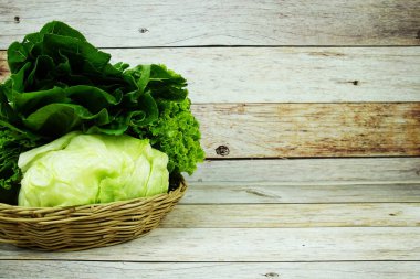 Taze çiğ Iceberg, Romaine ve Green Cos marulları bambu sepetinde ahşap arka planda