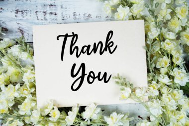 Ahşap arkaplanda çiçek desenli teşekkür mesajı