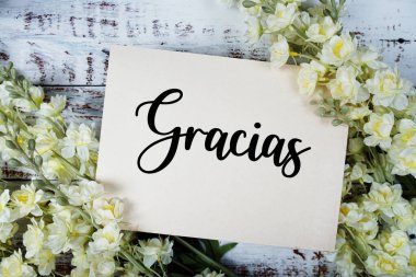 Ahşap arkaplanda çiçek süslemeli Gracias metni