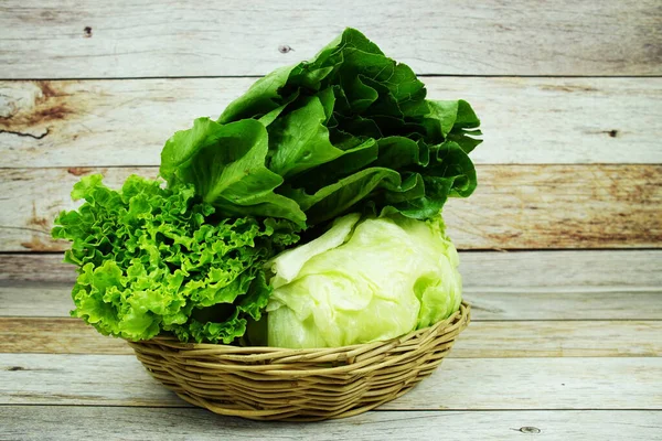 Taze çiğ Iceberg, Romaine ve Green Cos marulları bambu sepetinde ahşap arka planda