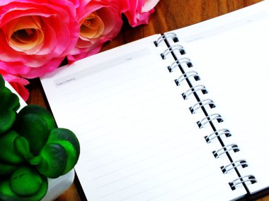 Açık not defteri ve grunge ahşap zemin üzerine güzel çiçekler buket