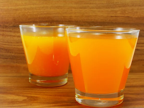 Świeżego soku pomarańczowego na drewnianym stole w tło grunge — Zdjęcie stockowe