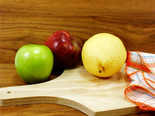 Grüner Apfel gelbe chinesische Birne und roter Apfel auf hölzernem Hintergrund — Stockfoto