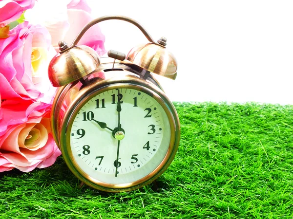 Alarm clock on artificial green grass — Stock Photo, Image