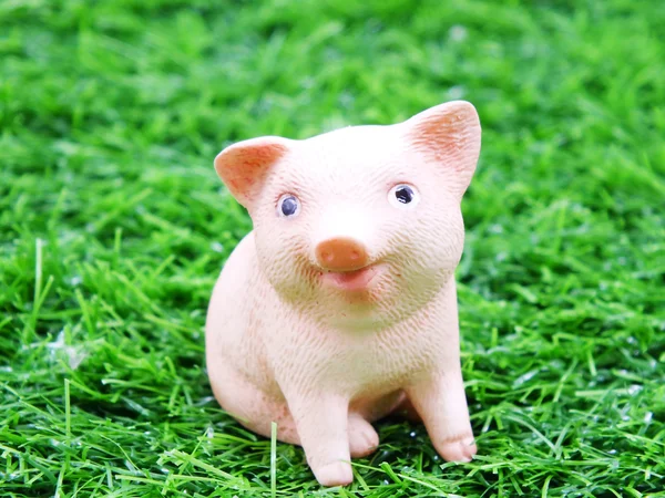 Mignon bébé sourire poupée d'argile de porc dans une herbe — Photo
