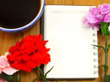 defter ve ahşap zemin üzerinde kahve