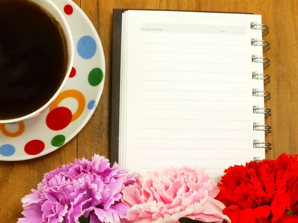 Notebook a kávy na dřevěné pozadí — Stock fotografie