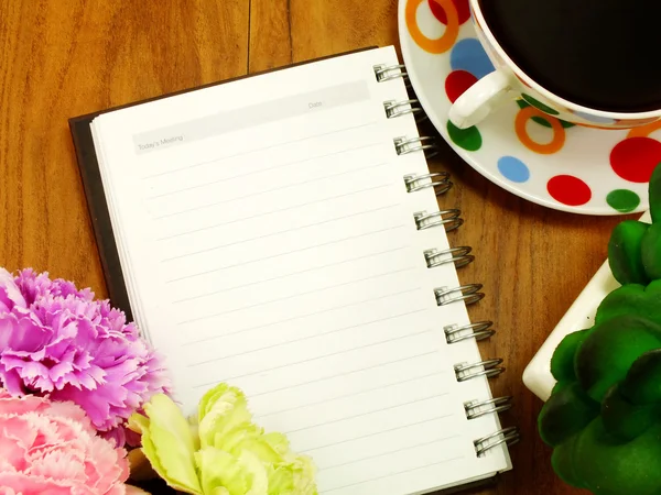 Notebook a kávy na dřevěné pozadí — Stock fotografie