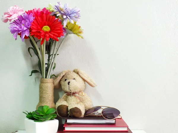 Conejito muñeca de conejo sentado en el cuaderno con la flor artificial naturaleza muerta —  Fotos de Stock