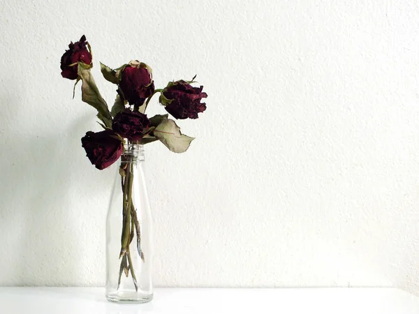 Bouqet of dried red roses in glass bottle — Stock Photo, Image