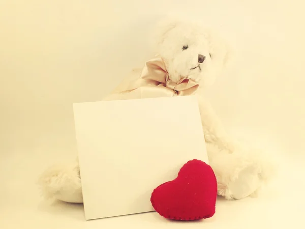 Ведмежа картка і мила лялька плюшевого ведмедя з червоним серцем на червоному точковому фоні з вінтажним фільтром кольору — стокове фото