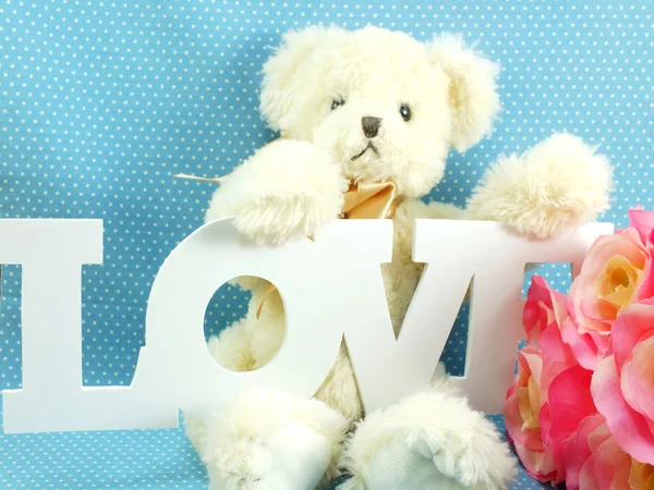 Niedliche Teddybär Konzept Valentinstag auf blauem Hintergrund und künstliche Blume — Stockfoto